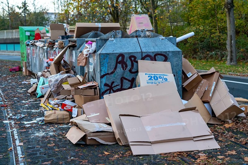 Overfilled waste paper containers, despite the overcrowding, people have put their waste paper next to them, Essen, North Rhine-Westphalia, Germany, Europe