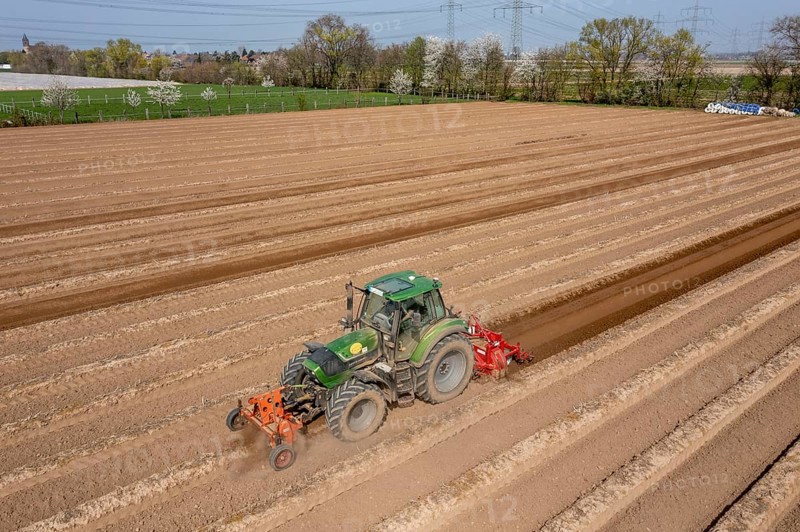 A farmer builds asparagus ridges on a field with the help of an asparagus tiller, in which the asparagus then grows, Dormagen, North Rhine-Westphalia, Germany, Europe