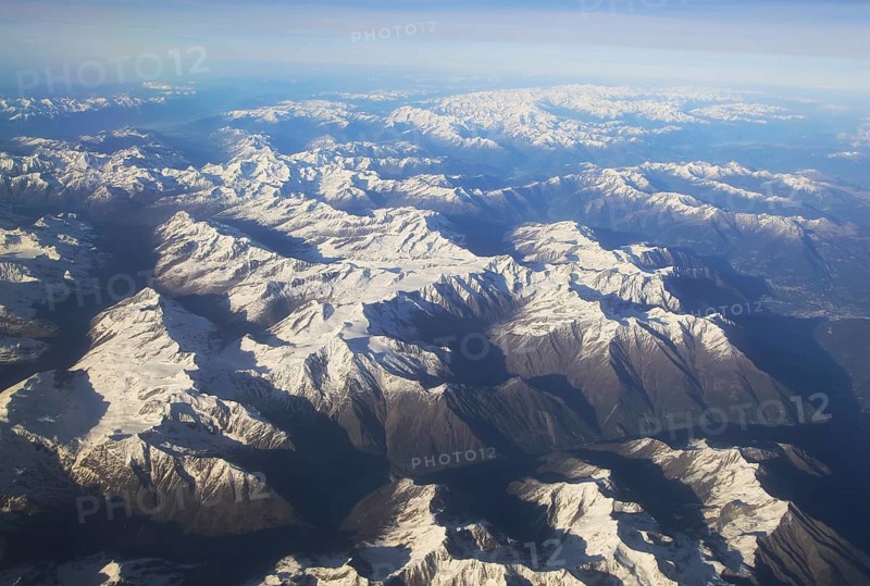 View from plane of snow covered mountain peaks in the Alps between France and Italy