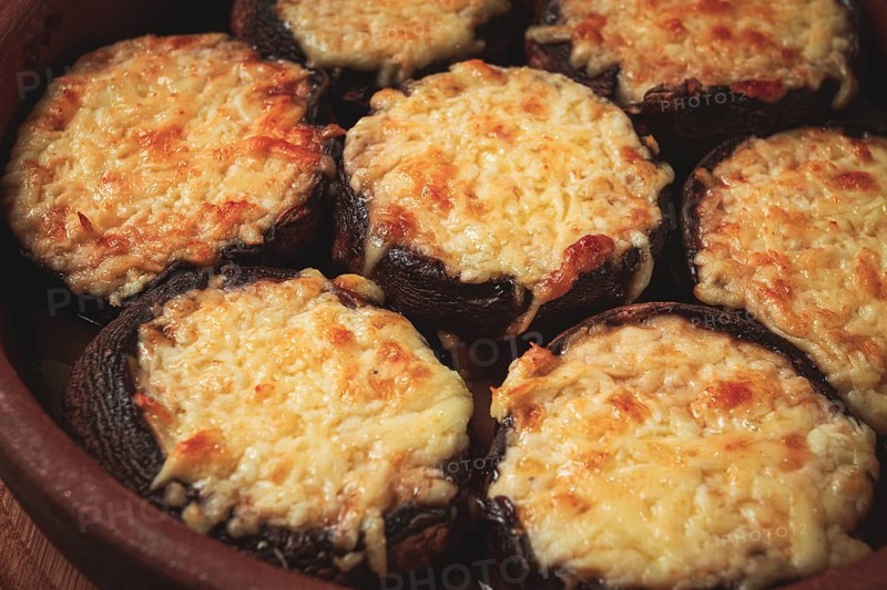 Portabello mushrooms stuffed with suluguni cheese in a clay pan, ketsi, Georgian cuisine, hot appetizer