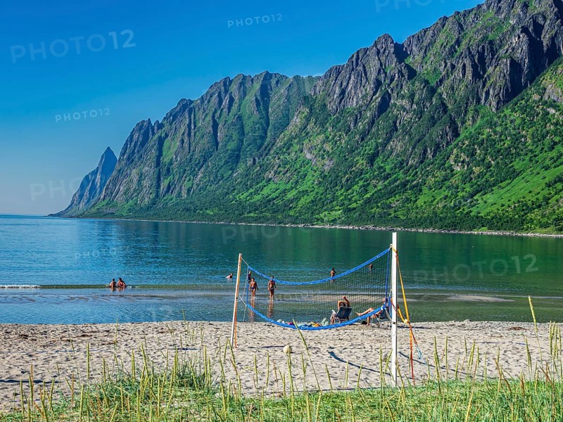 Beach Ersfjordstranden, fjord Ersfjord, public recreation area, summer, people go swimming, view to mountain range Okshornan, island Senja, Troms, northern Norway, Norway, Europe