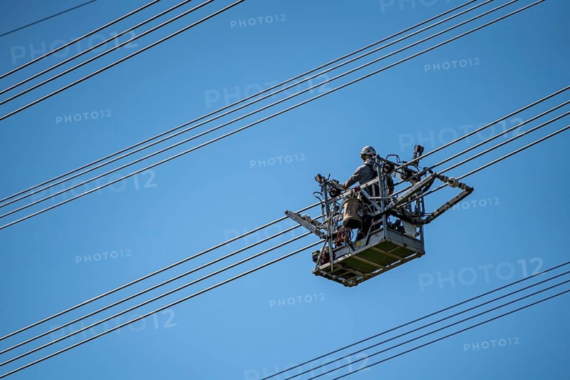 Construction of a new line route, 380 KV extra-high-voltage line between Osterath and Gohr, near Neuss, fitters in line trolleys, on the conductor cables, installing field spacers at great heights, North Rhine-Westphalia, Germany, Europe