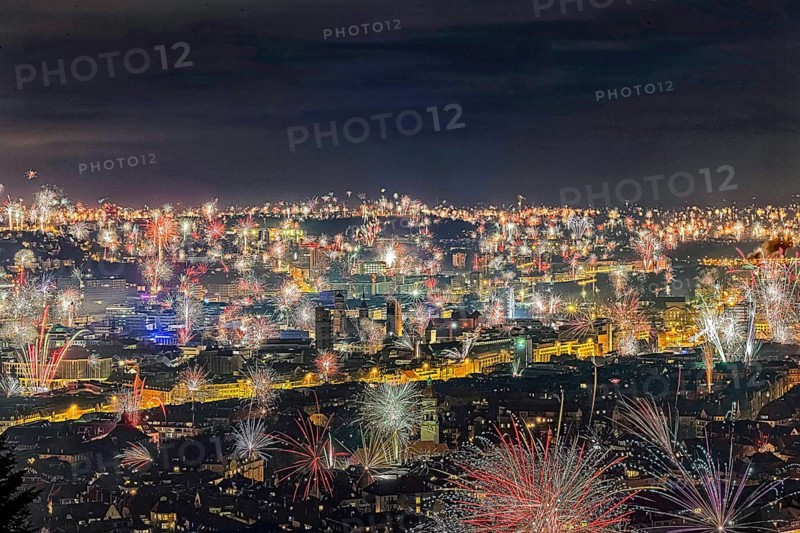 Stuttgart welcomes the New Year 2024 with fireworks over the city centre. In the centre of the picture: town hall tower, collegiate church and Old Palace, in the foreground the tower of St. Mark's Church, Stuttgart, Baden-Württemberg, Germany, Europe