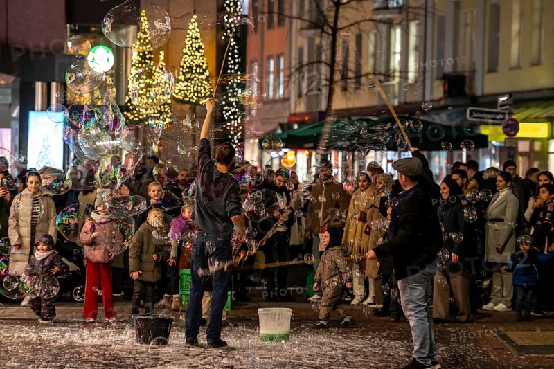 Pre-Christmas season, street artists, creating large soap bubbles, at Schadow-arcades, in the city centre of Düsseldorf, North Rhine-Westphalia, Germany, jeweller, Wempe, Europe