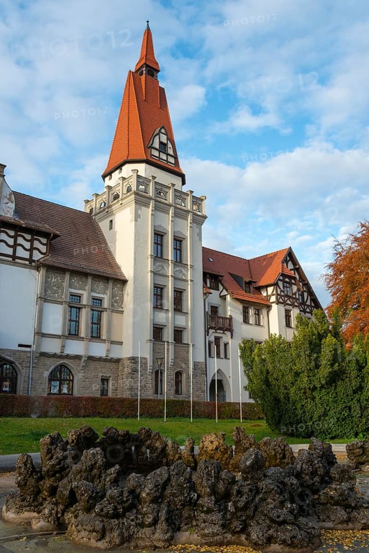 A historic building with a pointed tower and red roof, surrounded by autumn trees under a clear sky, spa hotel, Bernburg an der Saale, Saxony-Anhalt, Germany, Europe