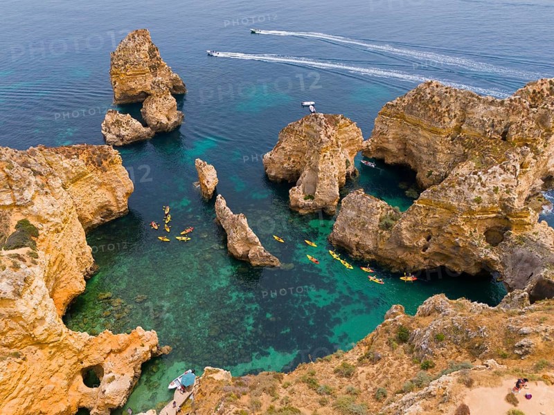 Rocky coast with turquoise-coloured water, kayaks and small boats. Impressive rock formations and natural scenery, aerial view, Ponta da Piedade, point of mercy, Lagos, Algarve, Portugal, Europe