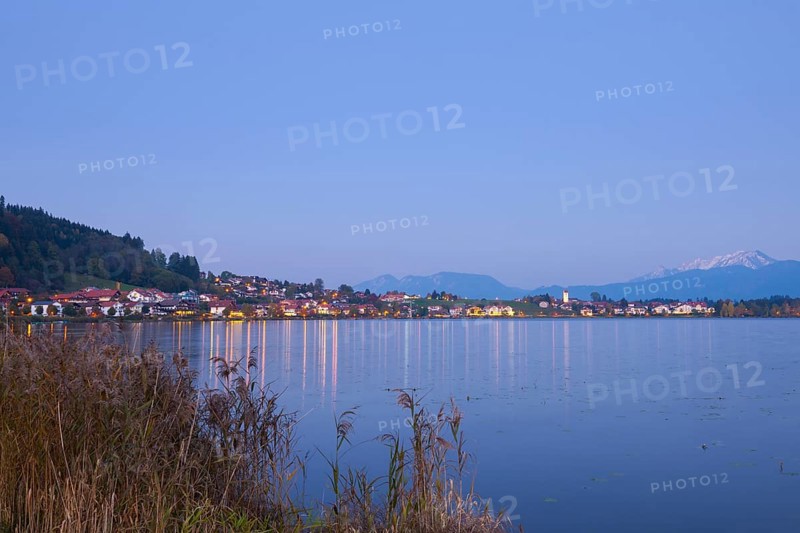 Village on the lakeshore at dusk, mountains in the background, quiet atmosphere, Hopfen am See, Ostallgäu, Allgäu, Swabia, Upper Bavaria, Bavaria, Germany, Europe