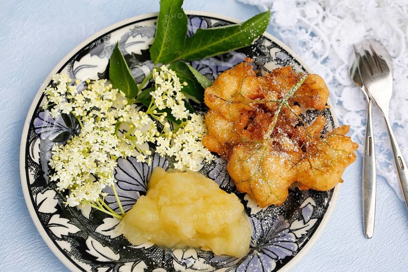 Swabian cuisine, elderberry cakes with apple sauce, Hollerkiacherl, elderflowers in pastry, dessert, dessert, fat baked, served on a plate, grandmother's kitchen, regional, home cooking, typical Swabian, classic recipe, traditional cuisine, food photography, studio, Germany, Europe