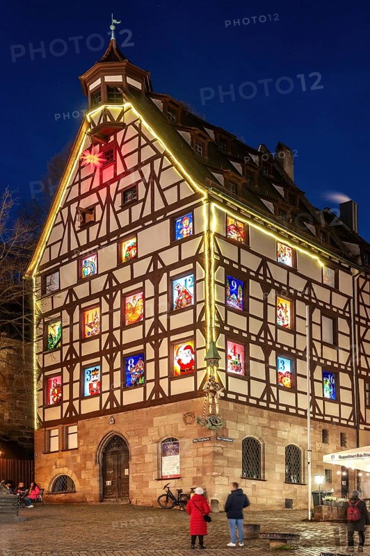 Pilatushaus, built in 1489, a historic town house with an Advent calendar on 18 December 2024 at dusk, the Imperial Castle on the right, Tiergärtnertorplatz, Nuremberg, Central Franconia, Bavaria, Germany, Europe