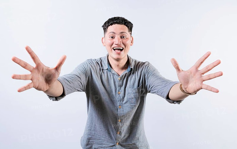 Happy young latin man welcoming with open arms isolated. Hospitable people opening arms to the camera. Smiling man asking for a hug