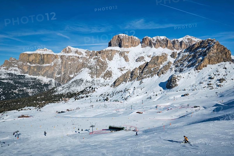 View of a ski resort piste with people skiing in Dolomites in Italy. Ski area Belvedere. Canazei, Italy, Europe