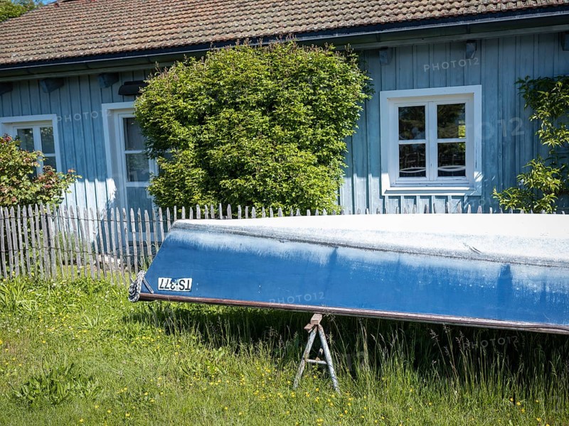 Boat and blue painted house on the Fraueninsel, Chiemsee, Bavaria, Germany, Europe