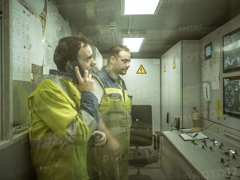 Workers in a control room of the double shield tunnel boring machine in section H53 of the Brenner Base Tunnel, Tyrol, Austria, Europe