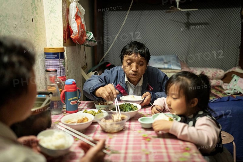 Gao Jian Min (67), Lin Shu Xiang (56) and Gao Xin Rui (5) having dinner, the grandmother bought Nanjing Salt Duck and grilled duck to supplement the dinner, Diao Yu Tai District, Nanjing, China, Asia