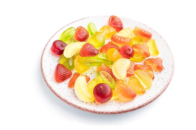 Various fruit jelly candies on plate isolated on white background. top view, flat lay, close up