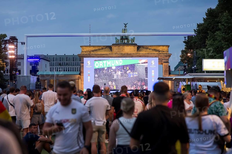 Fassball fans celebrate and gather information in the fan zone at the Brandenburg Tor after the interruption of the round of 16 match between Germany and Denmark due to a thunderstorm over the stadium in Dortmund, Berlin, 29 June 2024