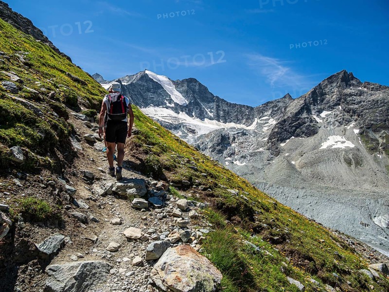 Hiking path up to mountain hut Cabane de Moiry, hiking tourists, Moiry glacier in the back, Valais, Switzerland, Europe