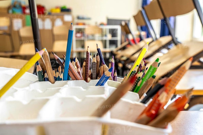 Classroom of a fourth grade, after school, the building is older but in good condition, coloured pencils