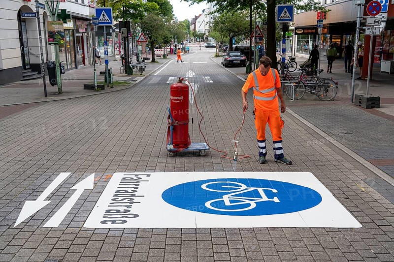 Application of road markings for a cycle lane, Rüttenscheider Straße in Essen, in the shopping and gastronomy district, cyclists have right of way over motorised vehicles, part of a cycle axis through Essen's city centre