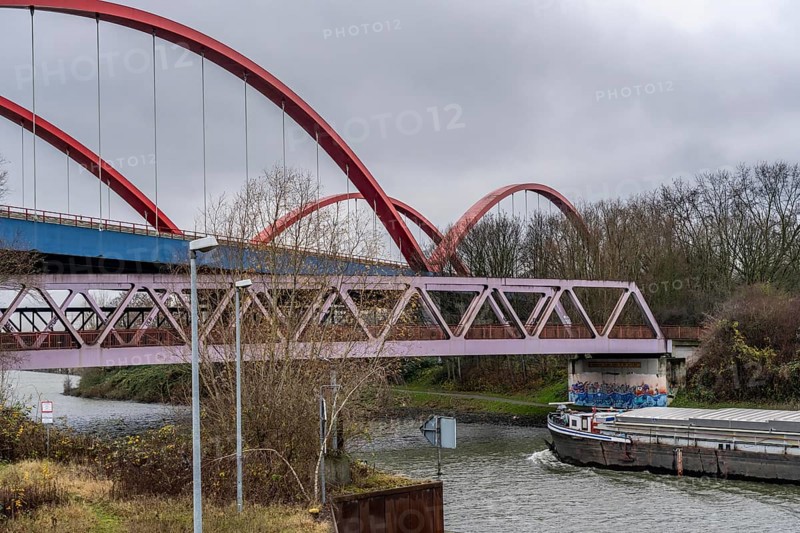 Freighter, dilapidated motorway bridge A42, (red arches) over the Rhine-Herne Canal, with massive structural damage, totally closed for the next few months, between the Bottrop-Süd and Essen-Nord junctions, for trucks probably until a new bridge is built, North Rhine-Westphalia, Germany, Europe