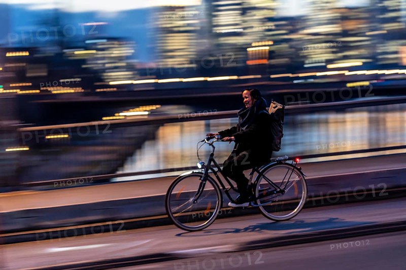 Skyline of the city centre of Frankfurt am Main, cyclist on the raft bridge, dusk, river Main, winter, Hesse, Germany, Europe