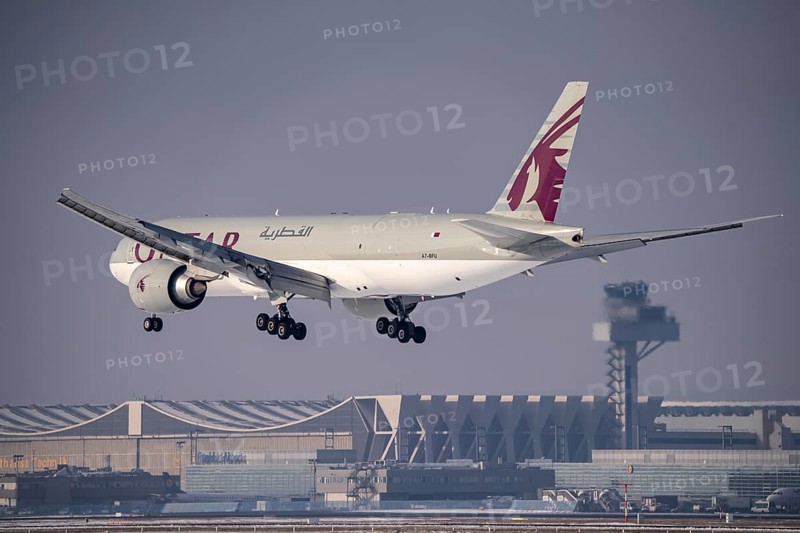 Qatar Airways Cargo Boeing 777F approaching Frankfurt FRA airport, air traffic control tower, Fraport, in winter, Hesse, Germany, Europe
