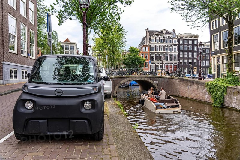 Mini car parked in the old town, Blauwburgwal canal, city centre of Amsterdam, Rocks Electric from Opel, e-car, popular in the city because it requires little parking space, may be driven at 15 years of age, with scooter driving licence, Netherlands
