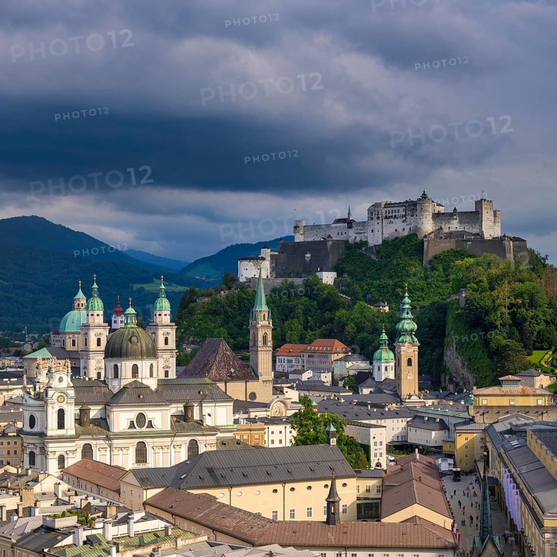 View of Salzburg's historic city centre with Hohensalzburg Fortress in the background under dramatic clouds, Salzburg, Salzburger Land, Austria, Europe