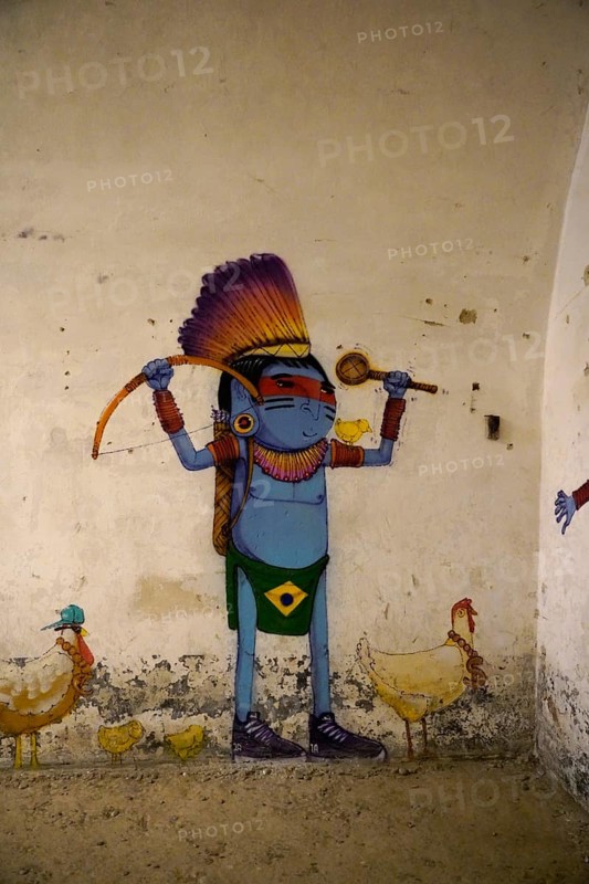 MAUSA VAUBAN, Museum of Urban Art and Street Art, Neuf-Brisach Fortress, France, Europe, A colourful graffiti depiction of a warrior with a bow, accompanied by chickens, on a wall, Europe