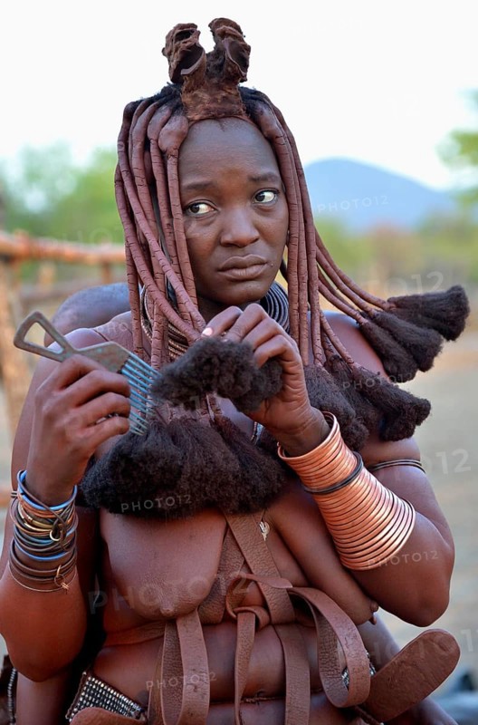 Himba woman combing her hair, Omuramba, Kaokoland, Kunene, Namibia, Africa
