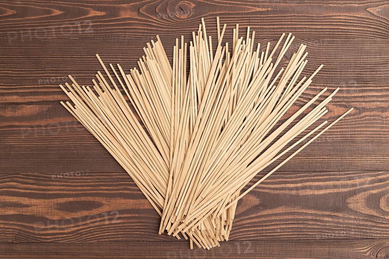 Japanese buckwheat soba noodles on brown wooden background. Top view, flat lay, close up