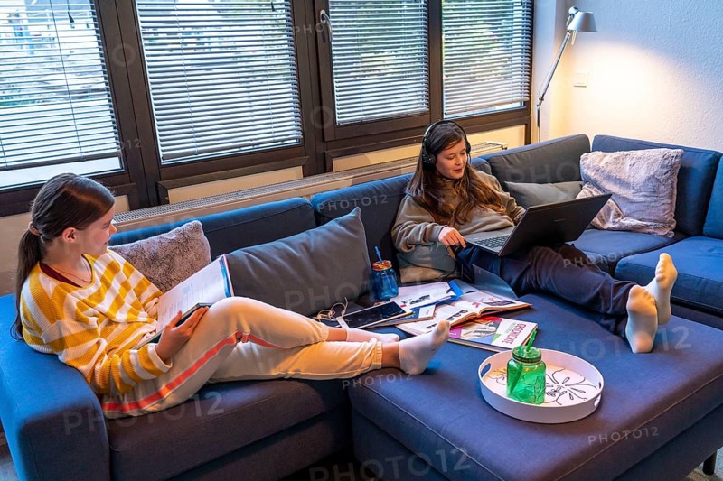 Homeschooling, 2 girls, sisters, 11 years old, learning at home, home learning, lessons at home, distance learning, chat with teachers and classmates via laptop, tablet PC, symbolic image