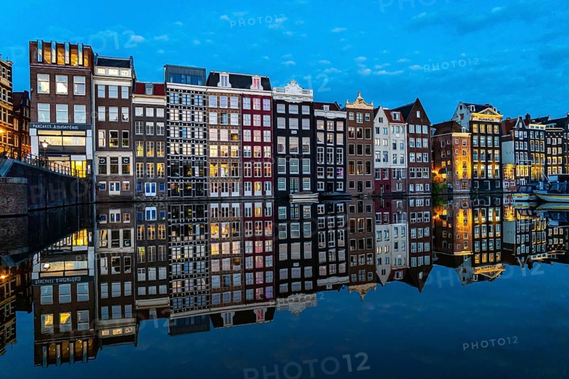 Canal houses on the Damrak, in the centre of the old town of Amsterdam, harbour, starting point of many canal tours, evening, Netherlands
