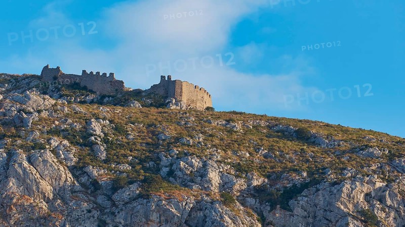 An ancient castle on the top of a rocky mountain under a blue sky with clouds, Archaic Castle, Akrokorinthos, Corinth, Peloponnese, Greece, Europe