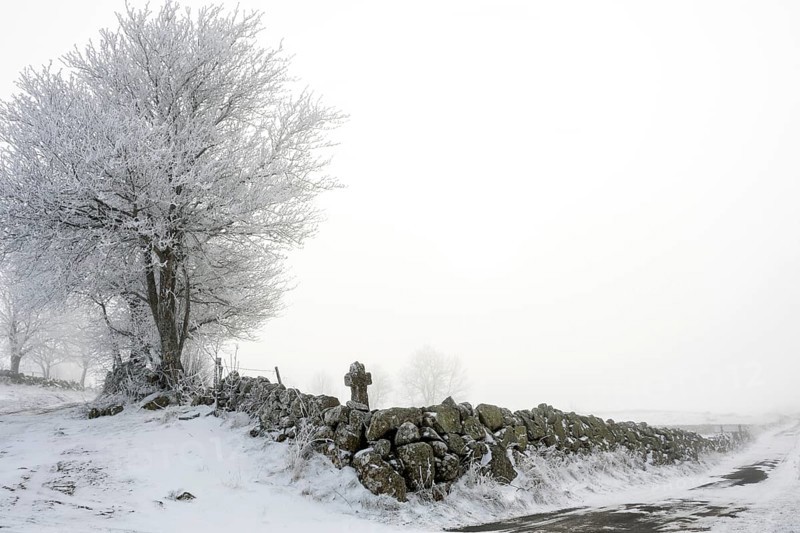 Aubrac plateau. Stone path cross in winter. Lozere department. Occitanie. France