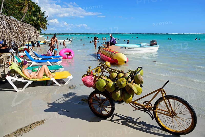 Caribbean beach with clear water, coconut sales and tourists sunbathing, Boca Chica, Santo Domingo Province, Dominican Republic, Hispaniola, Caribbean, America, Central America