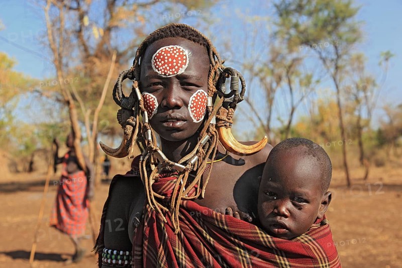 South Ethiopia, in Maco National Park, Mursi tribe, Mursi woman with baby, painted skin and headdress, Ethiopia, Africa