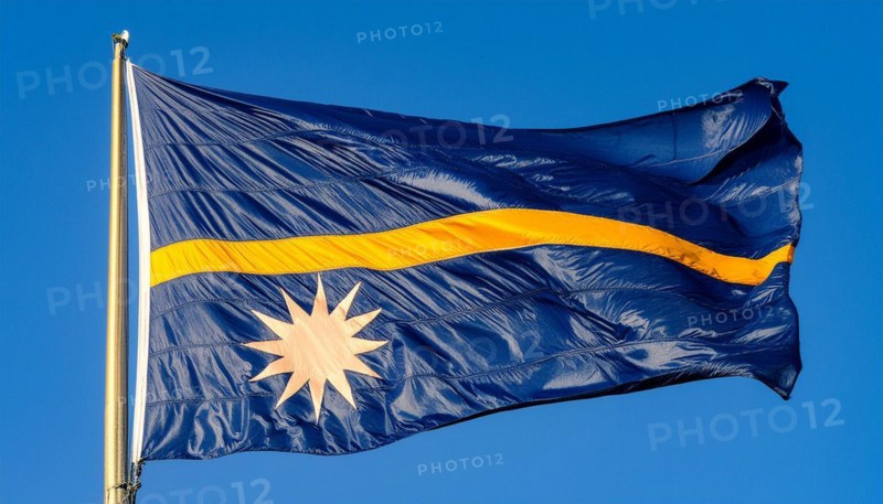 The flag of Nauru, an island nation in the Pacific Ocean, flutters in the wind, isolated against a blue sky