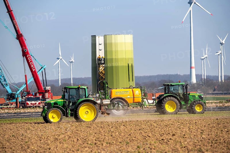 Construction of a wind turbine, Enercon steel pillar, near Kerken, Kleve district, on the Lower Rhine, farmer applying pesticide, North Rhine-Westphalia, Germany, Europe