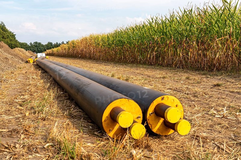 Laying of district heating pipes, next to a field, with maize, the district heating comes from a biogas plant and is fed directly into households in the neighbourhood, private provider, near Delbrück, North Rhine-Westphalia, Germany, Europe