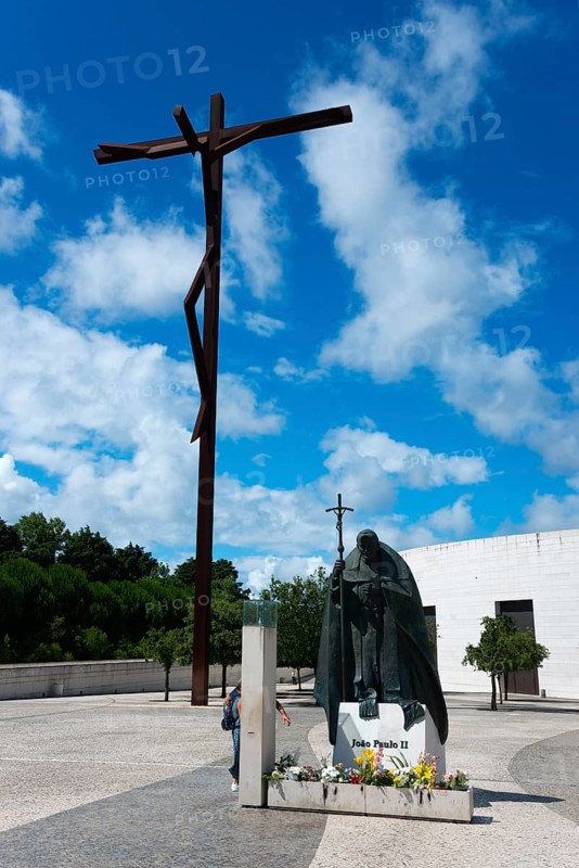 Large cross and statue of Pope John Paul II on a square with flowers and blue sky, Santuario de Fatima, place of pilgrimage, Fatima, Fátima, Ourem, Santarem, Portugal, Europe