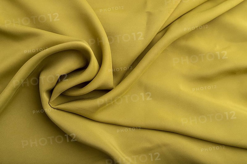 Fragment of green olive silk tissue. Top view, flat lay, natural textile background and texture. wave concept, abstract, spiral form