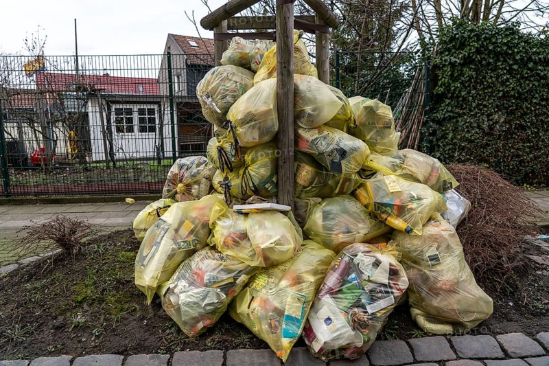 Yellow bags, stacked in a residential street, by a tree, waiting to be collected by a waste disposal company, recyclable household waste, part of the Dual System, Herne, North Rhine-Westphalia, Germany, Europe
