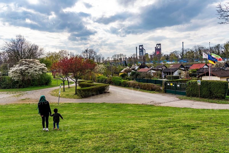 Allotment gardens along the A42 motorway, Emschertal allotment garden association, Emscherschnellweg, in Duisburg-Beeck, noise barrier, view of the ThyssenKrupp Steel Bruckhausen steelworks, blast furnaces 5 and 6, Duisburg, North Rhine-Westphalia, Germany, Europe