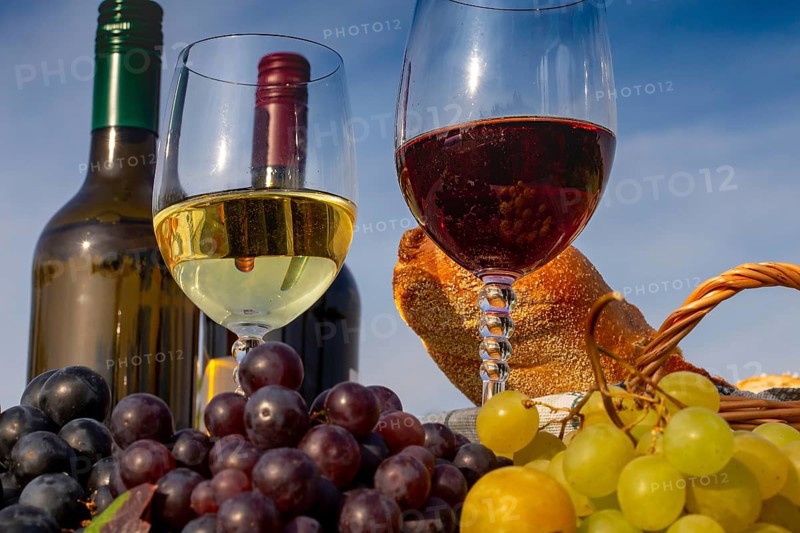 Symbolic image: Ripe grapes decorated with wine glasses on a wooden table