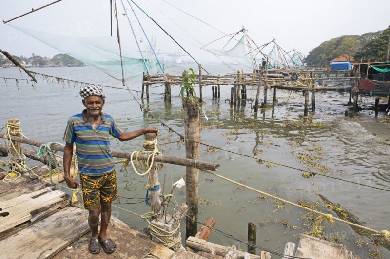 Indian fisherman standing at Chinese fishing nets, behind the Arabian Sea, Kochi, Kerala, India, Asia