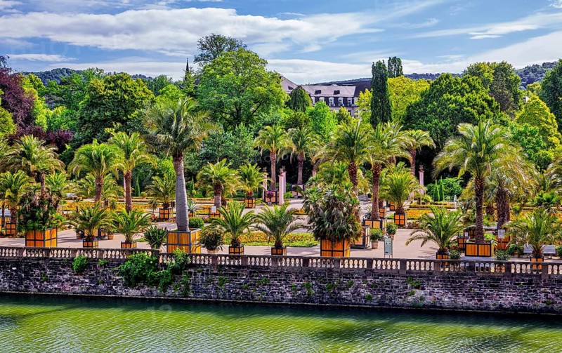 Castle moat with palm garden in the spa gardens, the largest outdoor palm garden north of the Alps, spa town of Bad Pyrmont, Lower Saxony state spa, Emmer, Emmertal, Weserbergland, Lower Saxony, Germany, Europe