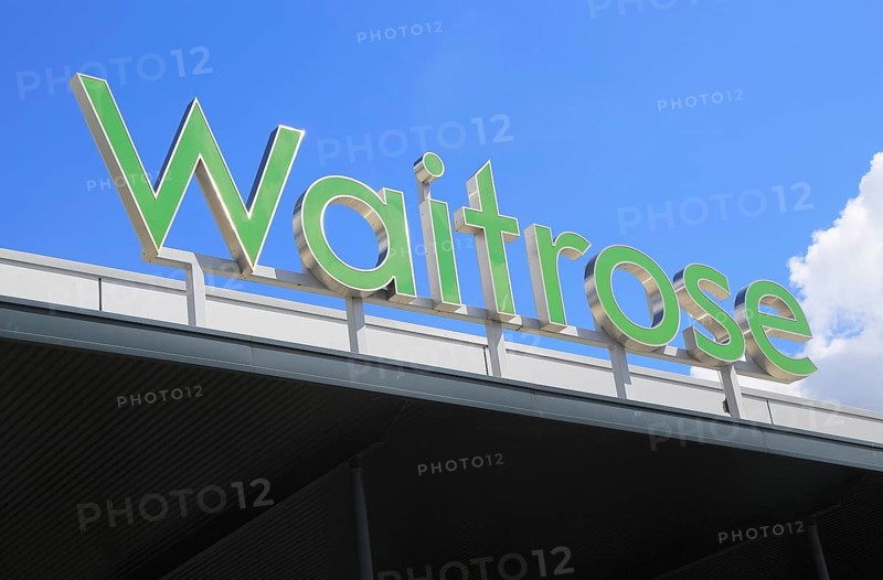 Green Waitrose supermarket shop sign against blue sky, Ipswich, Suffolk, England, UK