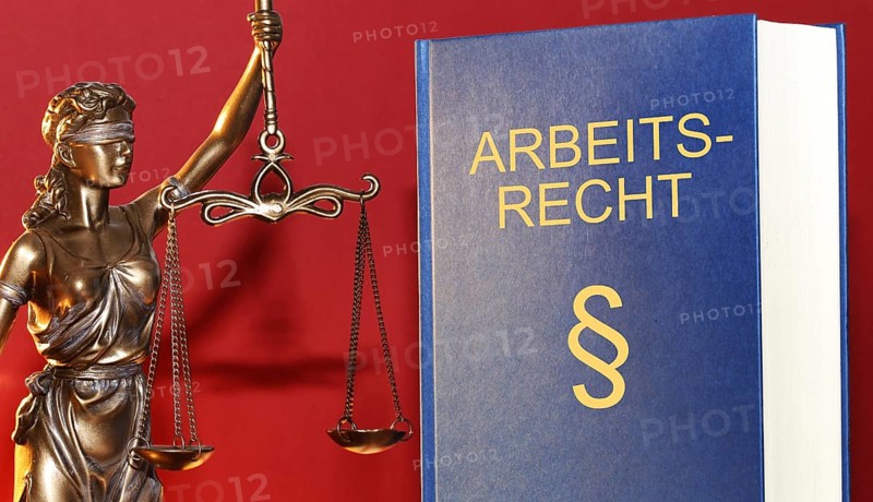 Symbolic image: Labour law reference book and a Justitia