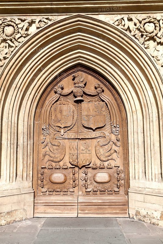 Detail of wooden door and stone arched entrance to the abbey church, Bath, Somerset, England, United Kingdom, Europe
